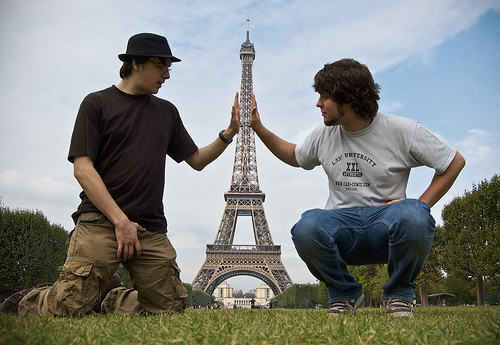 A photograph of two men appearing to push the Eiffel Tower from both sides - a trick created by them being in the foreground and the tower being in the background. Both points appear in focus as the correct aperture and point of focus has been selected.