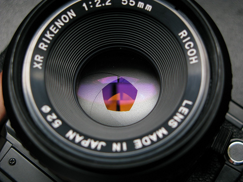 A photograph showing the aperture of a camera lens. It looks amazingly like the pupil of the human eye.