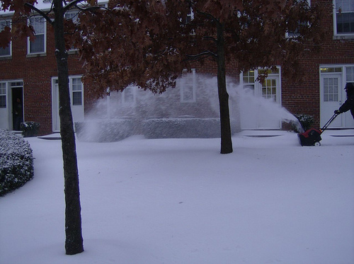 Photo of a snow covered area in front of a house where the snow appears dull due to underexposure