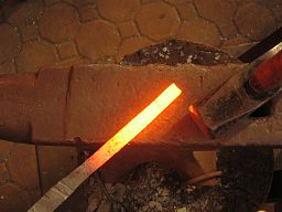 A metal rod that has been heated to a temperature where it begins to emit light.